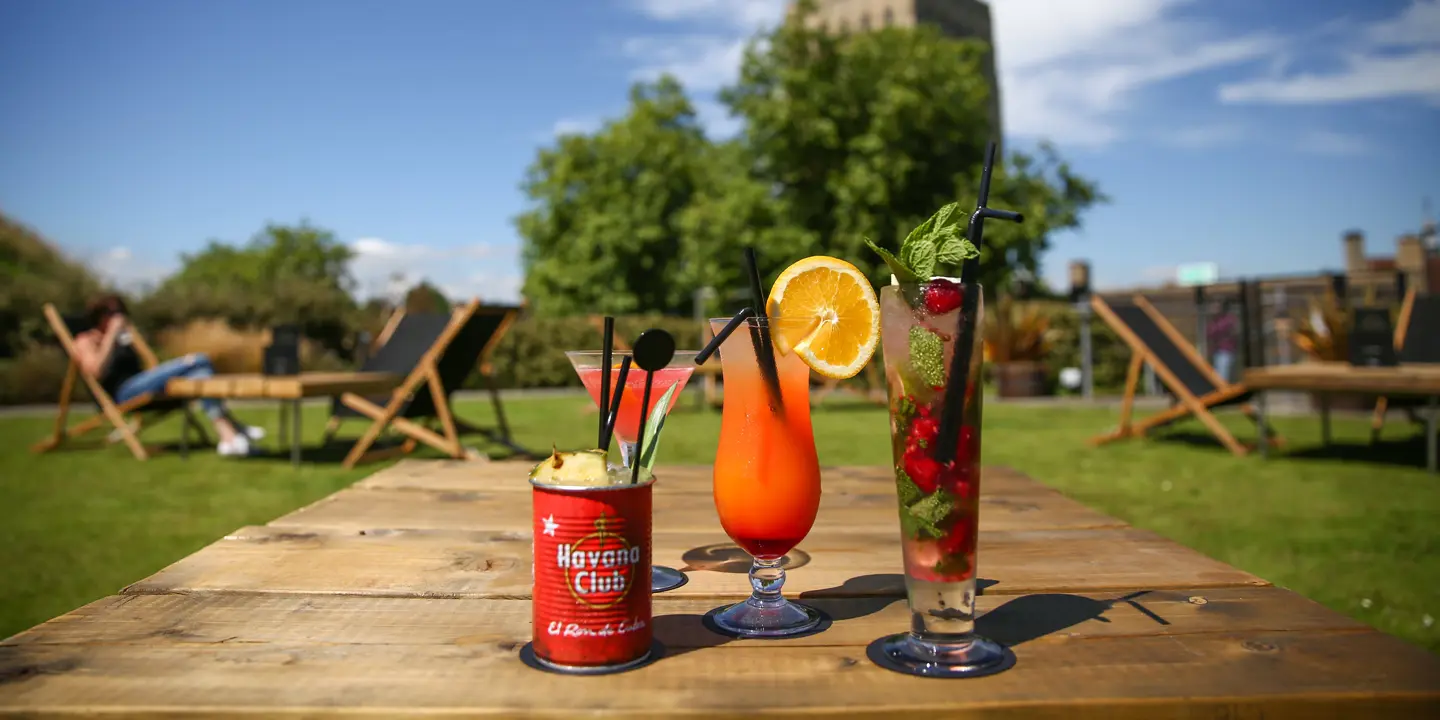Two glasses filled with drinks placed on a wooden table.