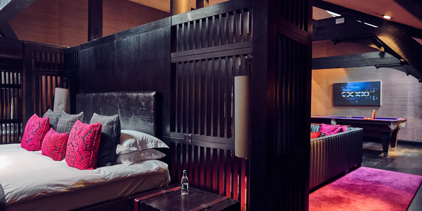 A bedroom with a comfortable bed with a black wooden headboard.