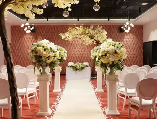 An elegantly decorated room adorned with pristine white chairs and delicate white flowers.