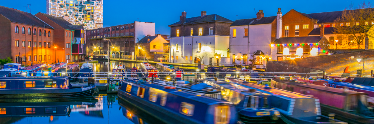 Narrow boats lit by street lighting at night.