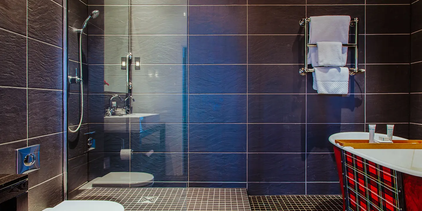 A bathroom featuring a shower, toilet, and sink.