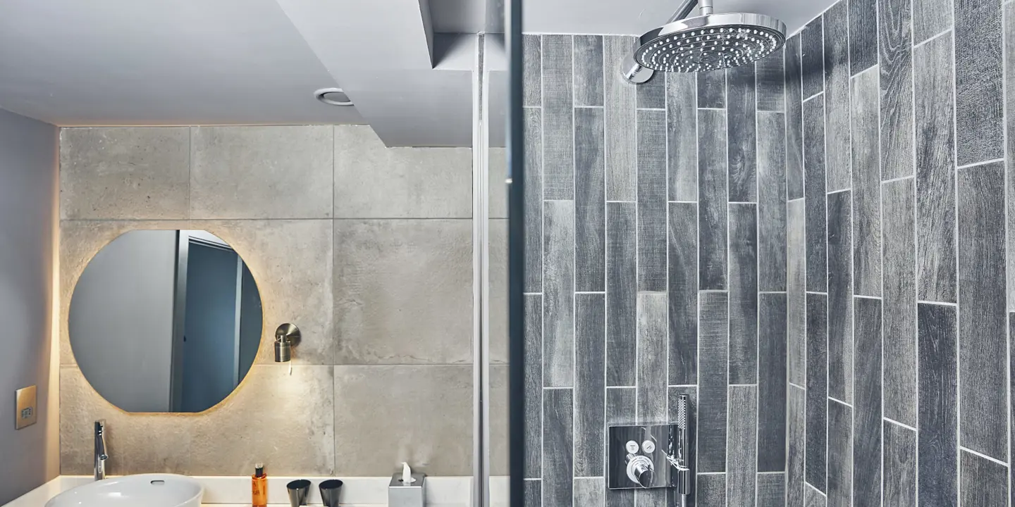 Bathroom featuring a shower, sink, and mirror.