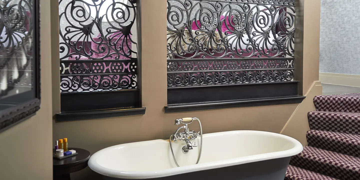 A bathtub positioned beside a bathroom window.