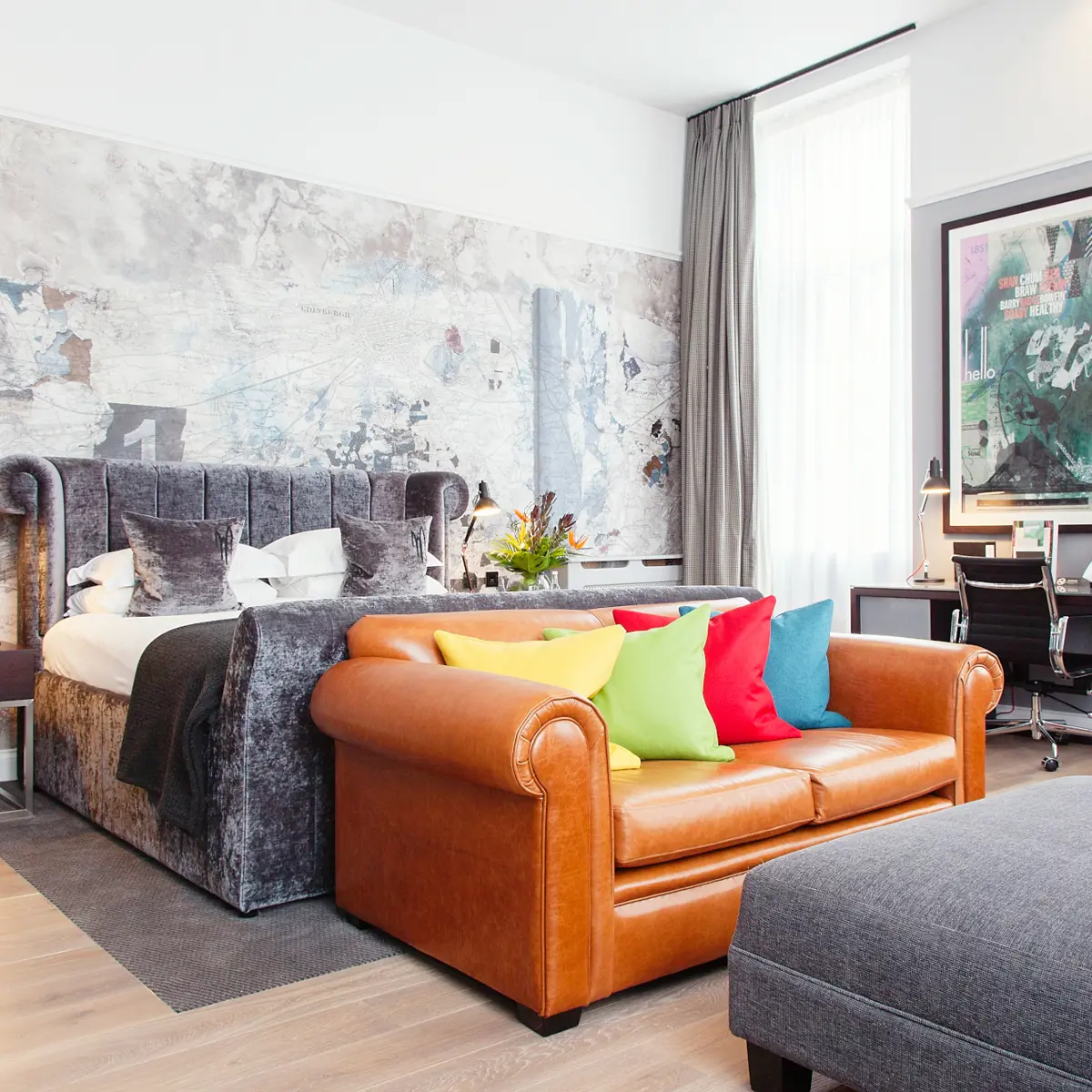 A well-furnished room featuring a brown leather sofa and a bed.