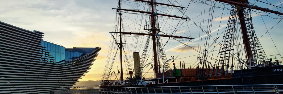 A majestic tall ship docked beside a serene body of water.