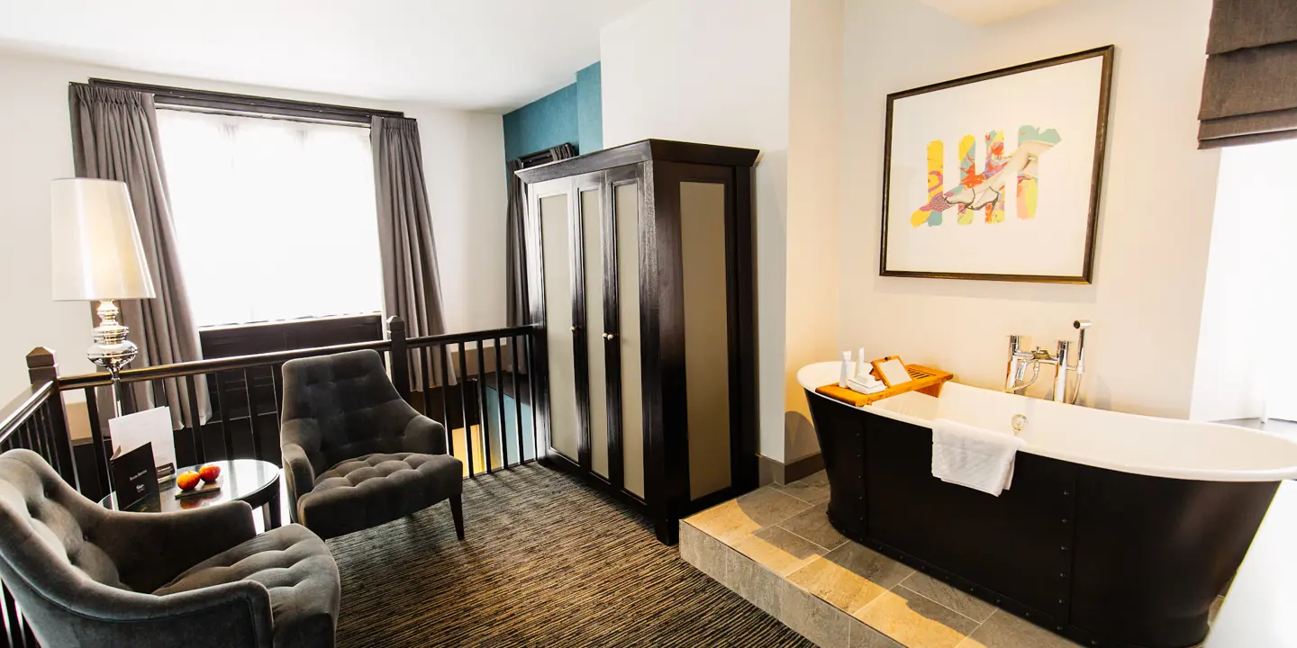 A bathroom featuring a bathtub and a chair.