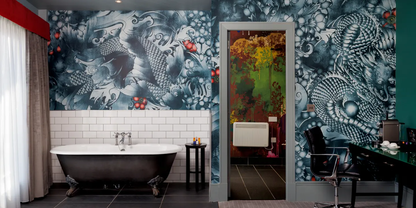 Bathroom with a bathtub placed beside a leather couch.