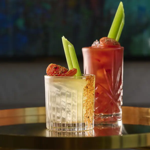 Two cocktail glasses placed on a table.